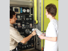 Noah McCrory gains knowledge of the fire truck water pump at the City of Stuart Fire Department.
